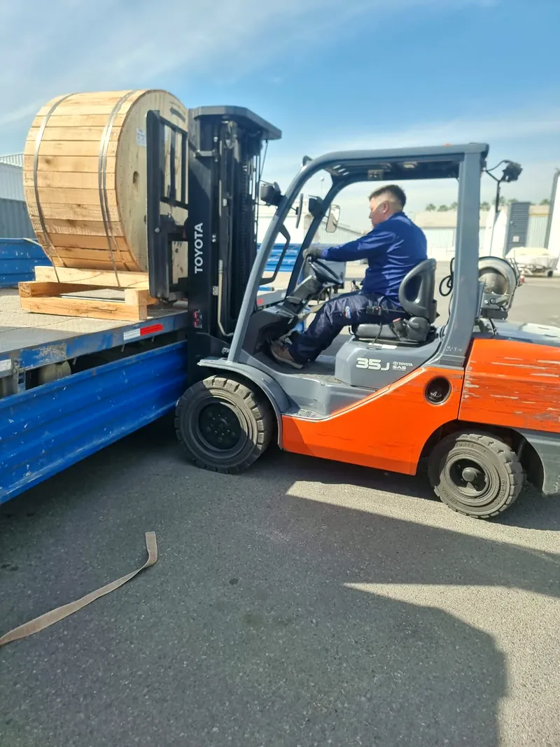 Carga de bobina de cable con grúa horquilla sobre rampla